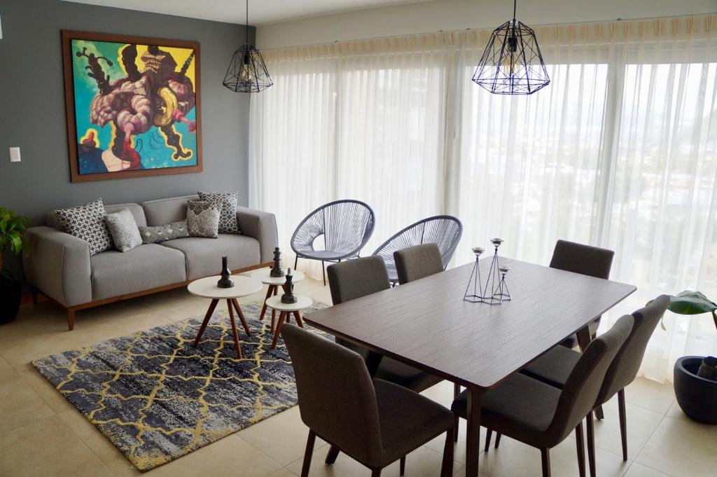 uma sala de estar com uma mesa e cadeiras e um sofá em Metropolitan Suites em Guadalajara