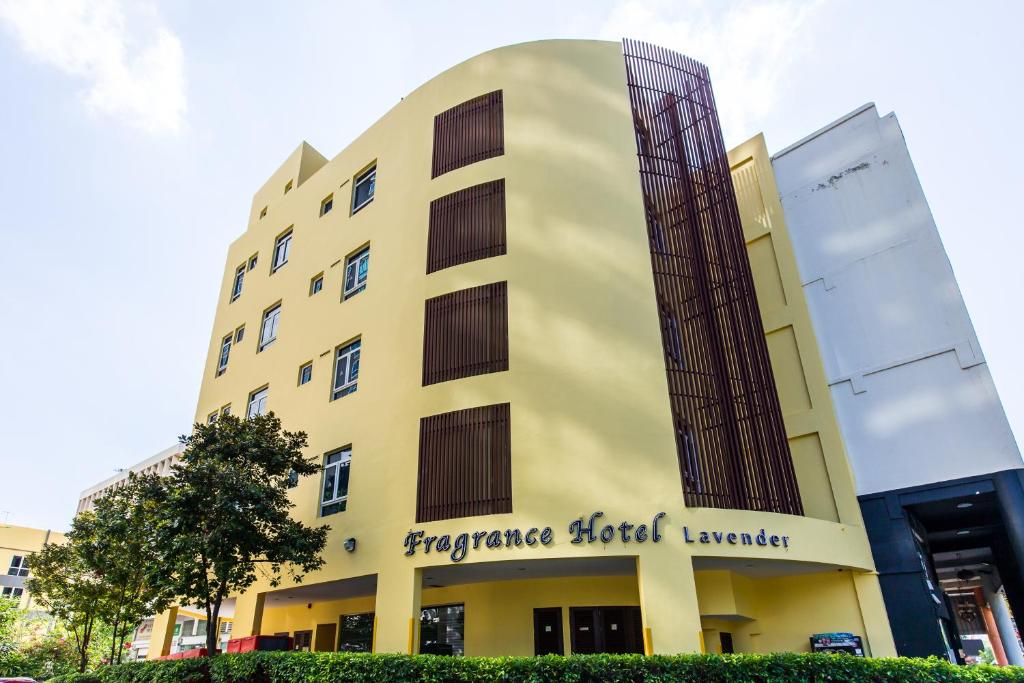 um edifício amarelo com o sinal de emergência do prestamista de sangue. em Fragrance Hotel - Lavender em Singapura