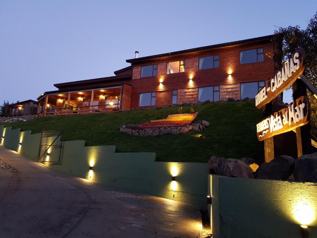 un edificio con una señal delante de él en Hotel y Cabañas Terrazas Vista al Mar hct, en Ancud