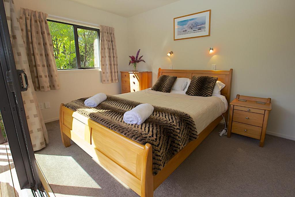 a bedroom with a large bed and a window at Crescent House in Wanaka