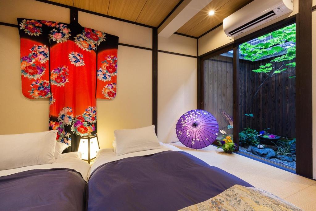 two beds in a room with flowers on the wall at Gion guesthouse YURURI / Vacation STAY 4147 in Kyoto