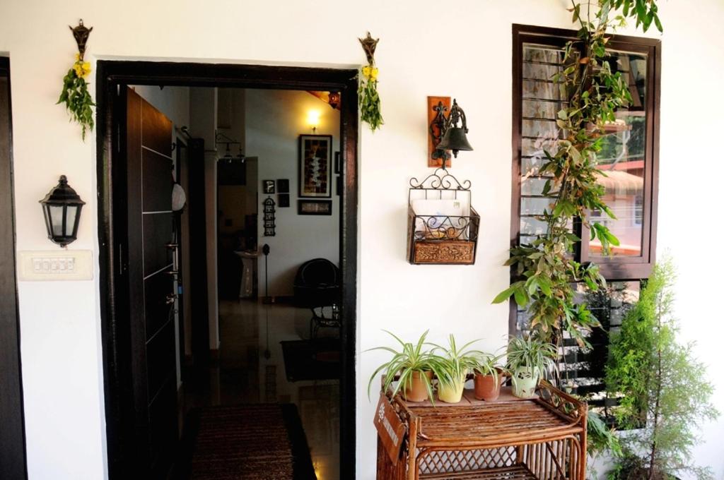 Una porta per una casa con delle piante in vaso. di Cornwall Coorg a Madikeri