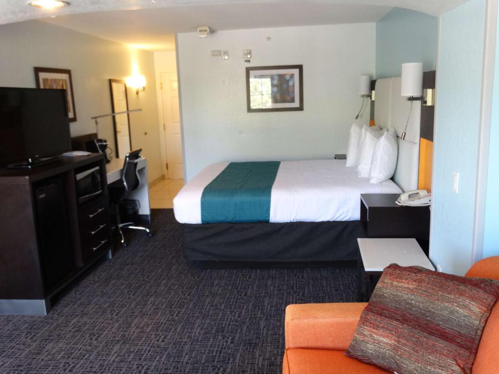 a hotel room with a bed and a tv at Best Western Plus Orlando Lake Buena Vista South Inn & Suites in Kissimmee