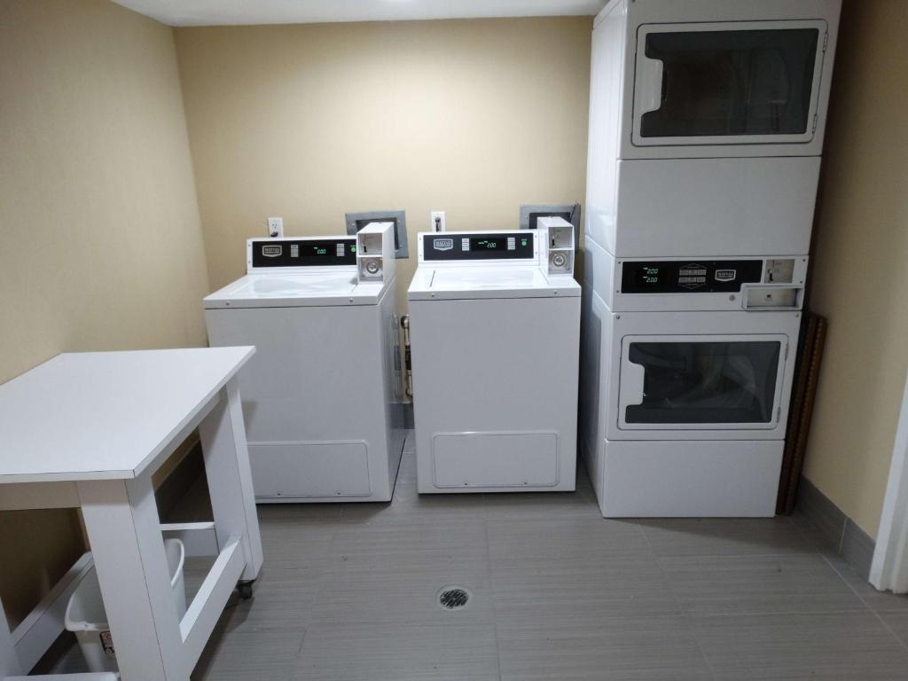 a room with three machines and a table in it at Best Western Plus Orlando Lake Buena Vista South Inn & Suites in Kissimmee