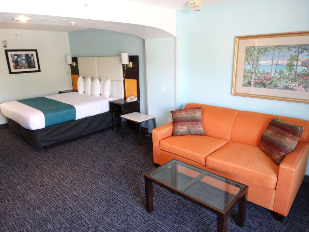 a hotel room with a bed and a couch at Best Western Plus Orlando Lake Buena Vista South Inn & Suites in Kissimmee