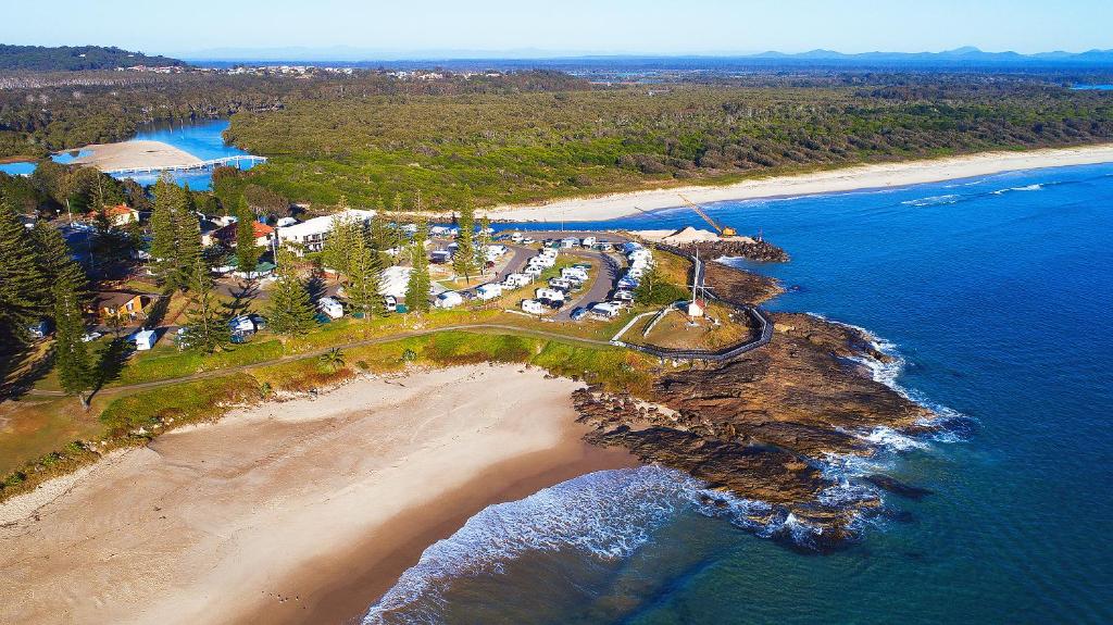 an aerial view of a resort on a beach at Horseshoe Bay Holiday Park in South West Rocks