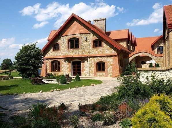 a large brick house with a stone driveway at Zajazd Kmicic in Zemborzyce Dolne