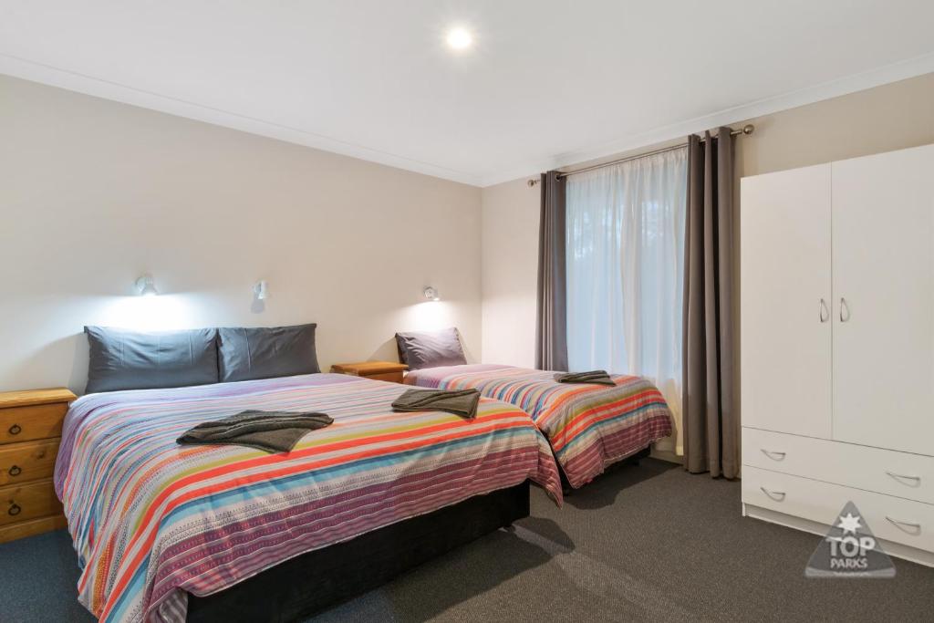 a bedroom with two beds and a large window at Margaret River Tourist Park in Margaret River Town