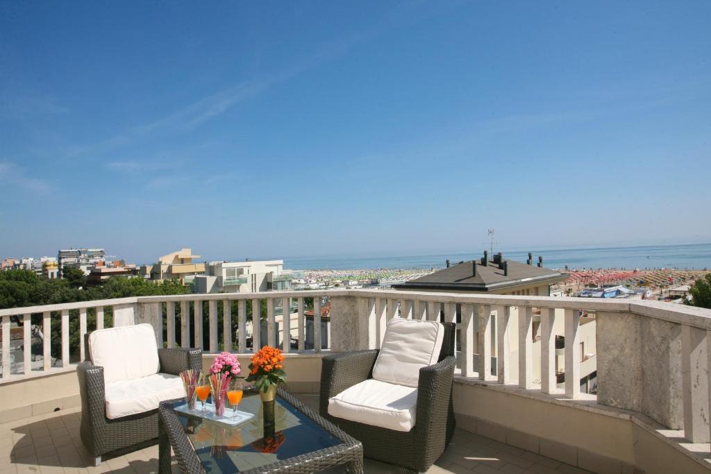 a balcony with chairs and a table with a view of the ocean at Residence Internazionale in Rimini