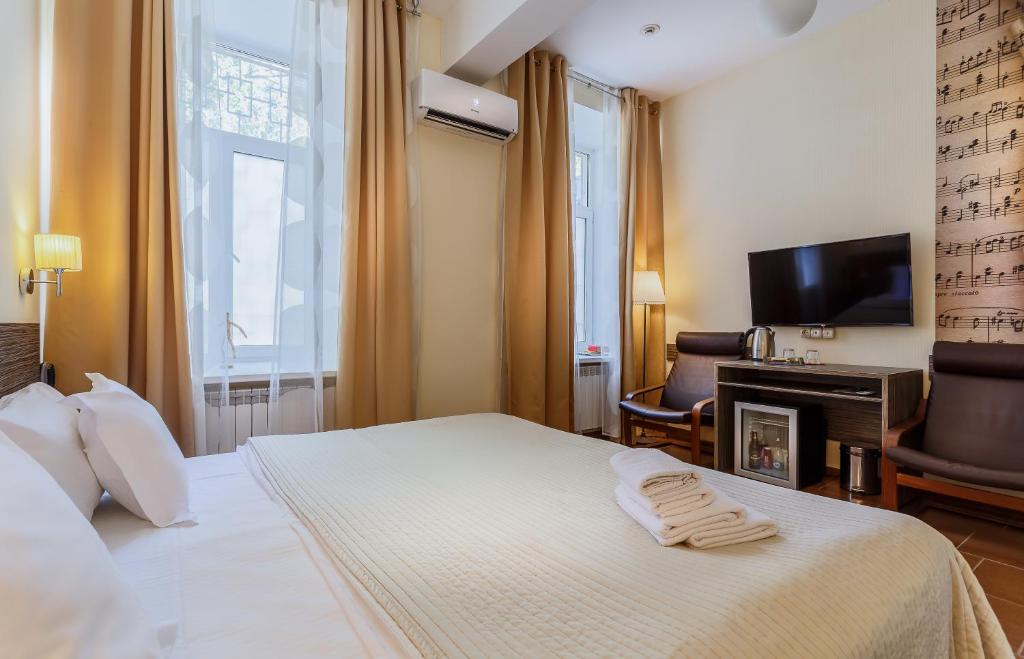 モスクワにあるジャズ ホテルのベッドとテレビが備わるホテルルームです。