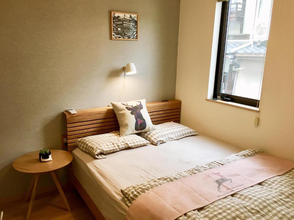 um pequeno quarto com uma cama e uma mesa em Mini inn Nara- - 外国人向け - 日本人予約不可 em Nara