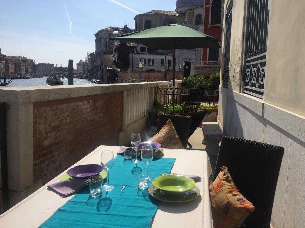 einen Tisch mit Tellern und Gläsern auf dem Balkon in der Unterkunft Terrazza Momon in Venedig