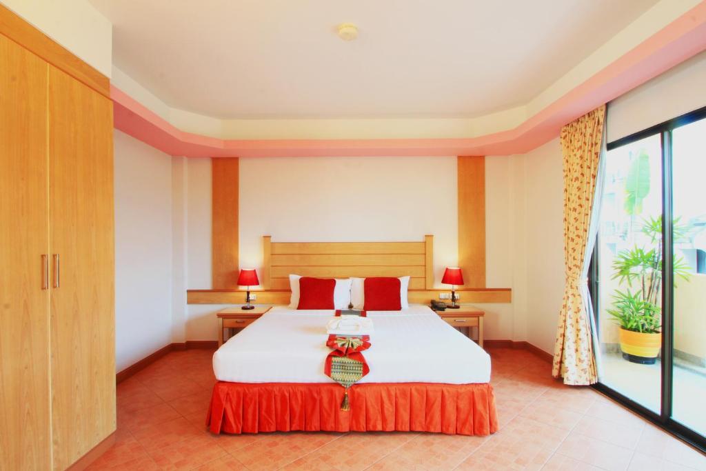 a bedroom with a large bed with red pillows at Baan Boa Resort in Patong Beach
