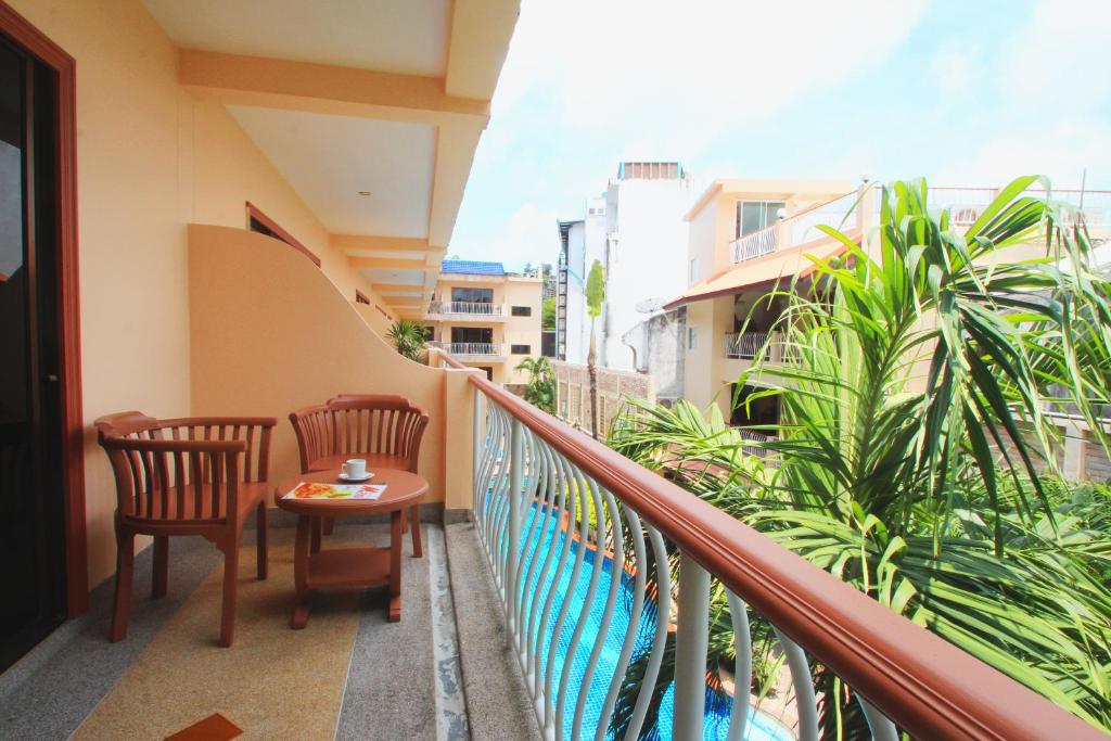 a balcony with two chairs and a table on it at Baan Boa Resort in Patong Beach