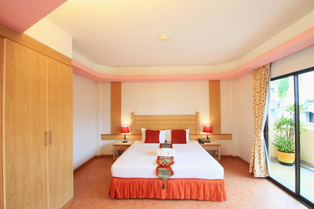 a bedroom with a bed and a large window at Baan Boa Resort in Patong Beach