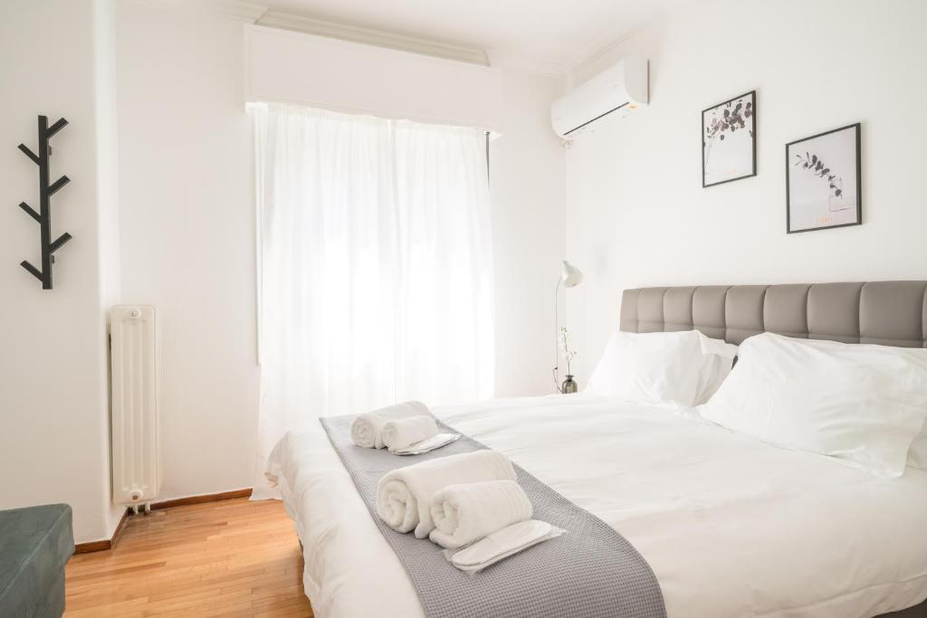 een slaapkamer met een wit bed en handdoeken bij Modern design apartment near Acropolis 2 in Athene