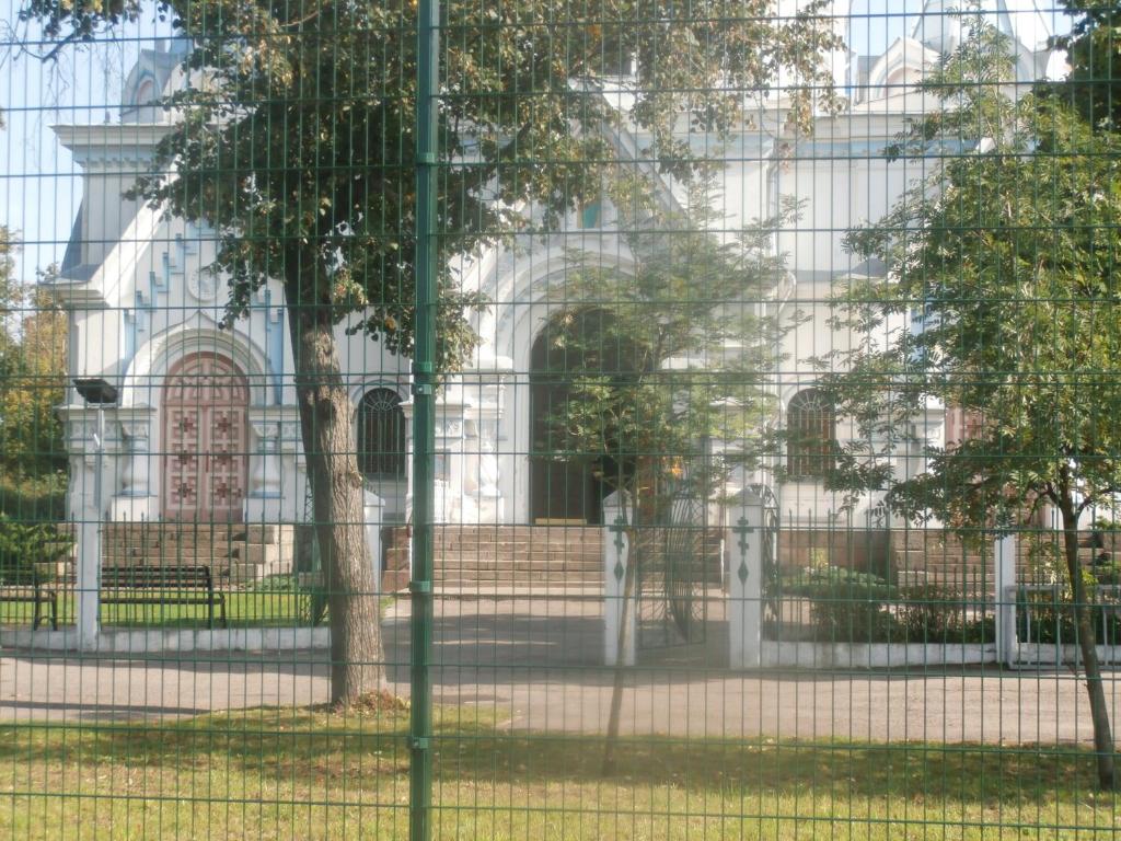 uma cerca em frente a um edifício em Apartments at the church alley em Daugavpils