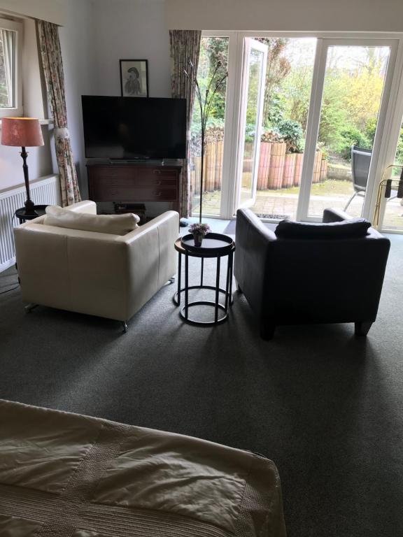 a living room with two couches and a flat screen tv at Villa 't Haasduin in Wijk aan Zee