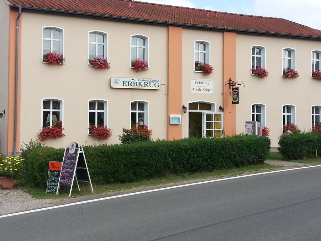 un bâtiment situé sur le côté d'une route dans l'établissement Erbkrug Gasthof & Pension, à Blankensee