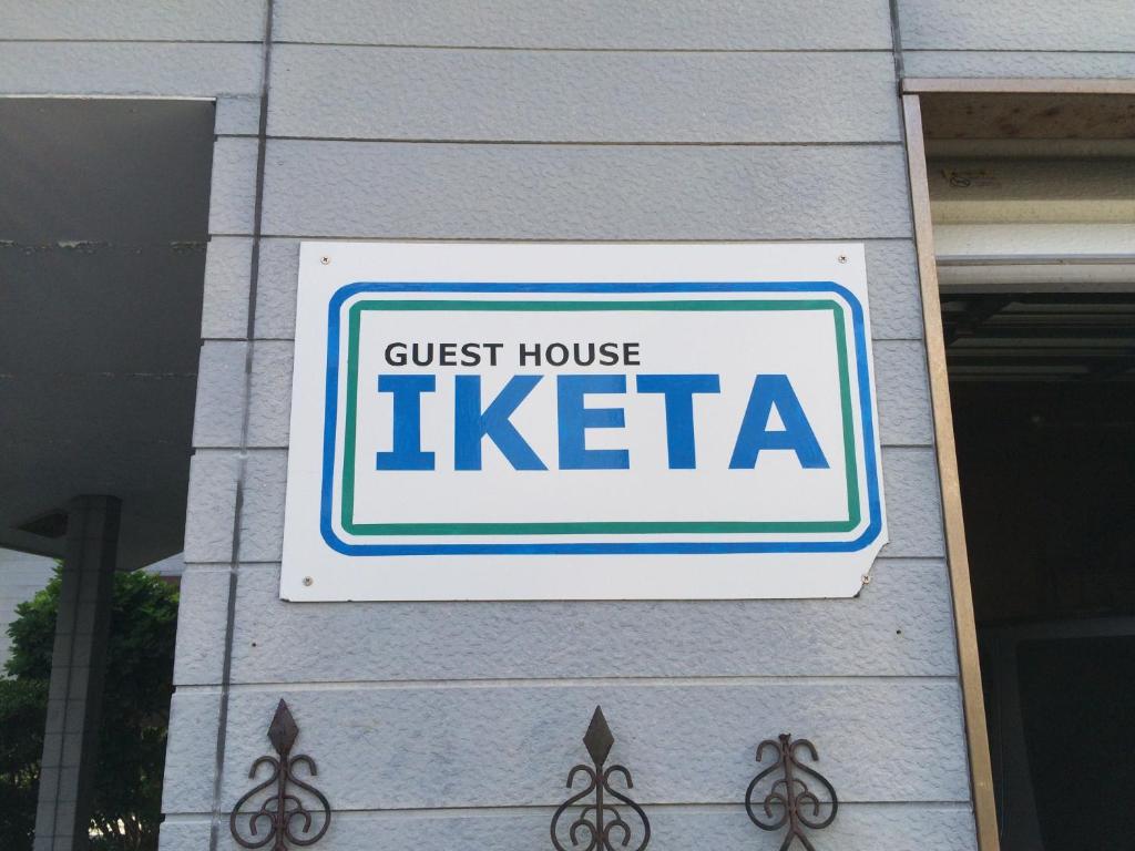 a sign for a guest house in a building at Guesthouse IKETA in Niijimamura