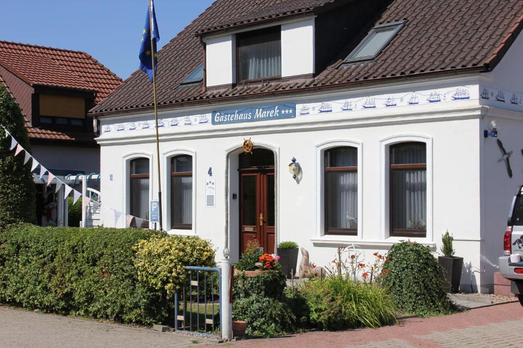 a white building with a brown roof at Gästehaus Marek in Nordenham