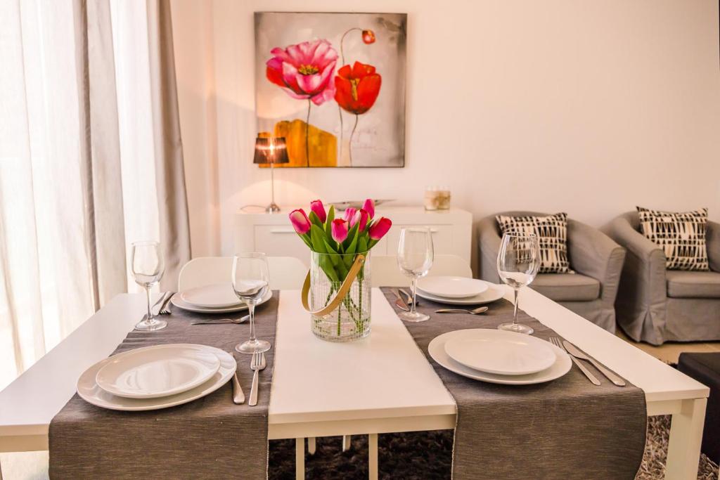 un comedor con una mesa con platos y copas de vino en Apartamento Moderno, en Valladolid