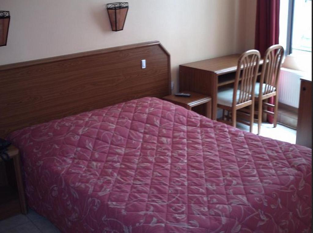 1 dormitorio con cama morada y escritorio en Paris Hôtel Le Mediterraneen, en París