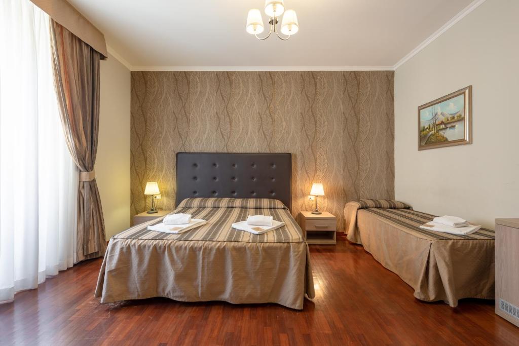 ローマにあるDreams Roma B&Bのベッド2台とテーブル2台が備わるホテルルームです。