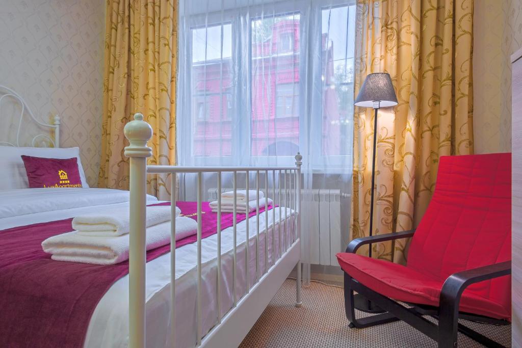 モスクワにあるLux-Apartments метро Парк Культурыのベッドルーム1室(ベッド1台、赤い椅子付)