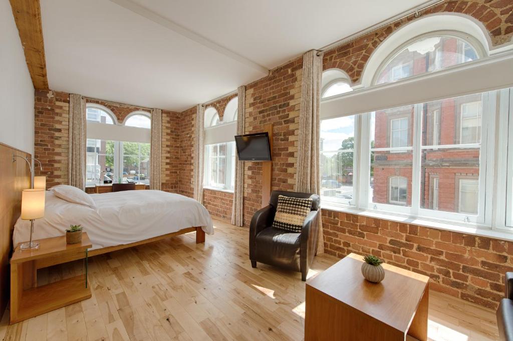 een slaapkamer met een bed en een bakstenen muur bij Hope Street Hotel in Liverpool