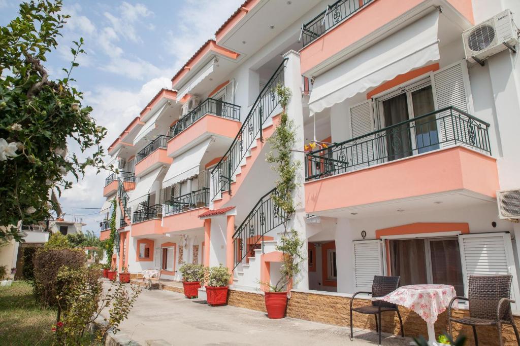a row of pink and white apartment buildings at Marmaron Rooms in Agiokampos