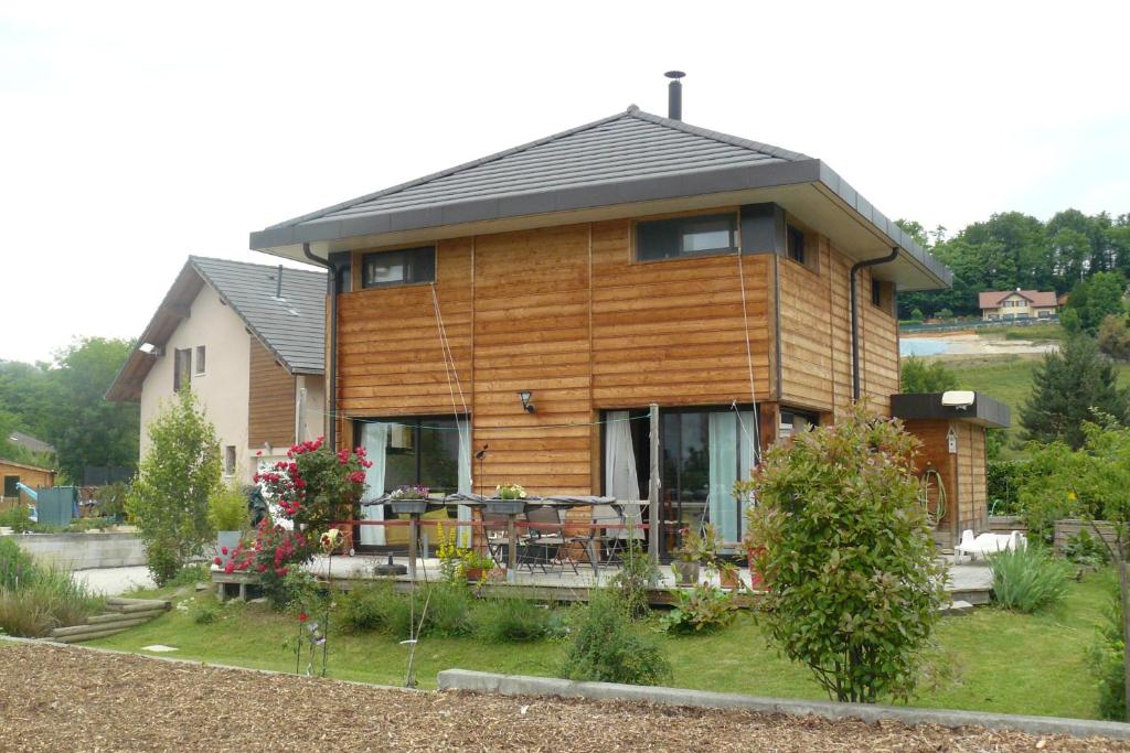 una grande casa in legno con patio nel cortile di Chambre chez l'habitant a Hauteville-sur-Fier