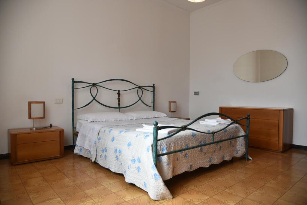een slaapkamer met een bed en twee nachtkastjes bij Appartamento Golfo dei Poeti in La Spezia
