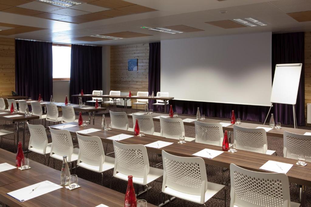 a conference room with tables and chairs and a whiteboard at Résidence Le Chalet du Mont Vallon in Les Menuires