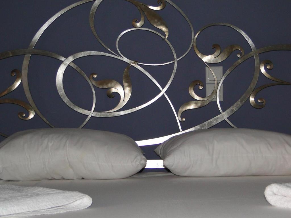 cabecero de metal con 2 almohadas en una cama en Villa Marios- Under the Volcano, en Zefiría