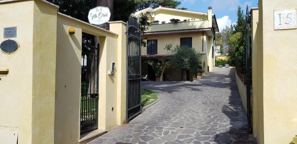 eine leere Straße mit einem Gebäude und einem Tor in der Unterkunft Villa Orsini in Tor Vergata