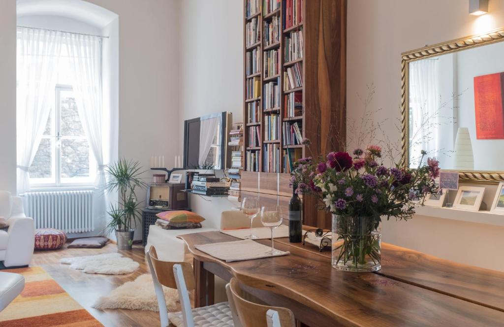 a room with a table with a vase of flowers at Spacious old town luxury apartment in Linz