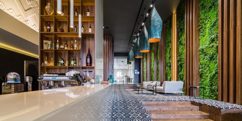 a lobby with a bar with plants on the walls at Unirea Hotel & Spa in Iaşi