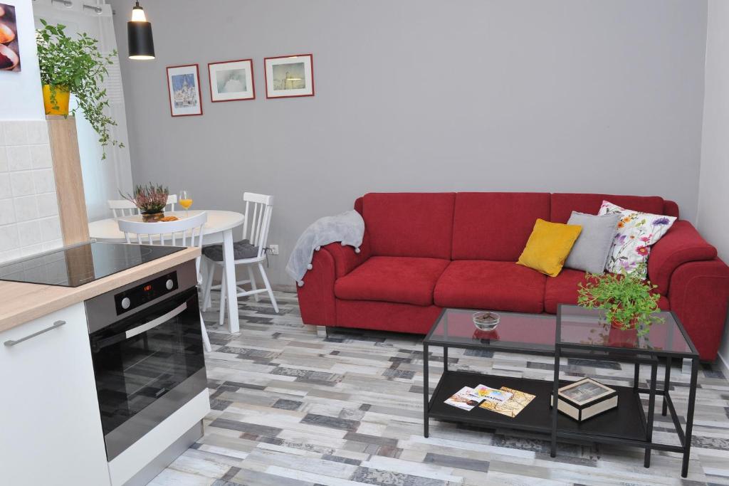 a living room with a red couch and a table at Studio apartman D&D in Varaždin