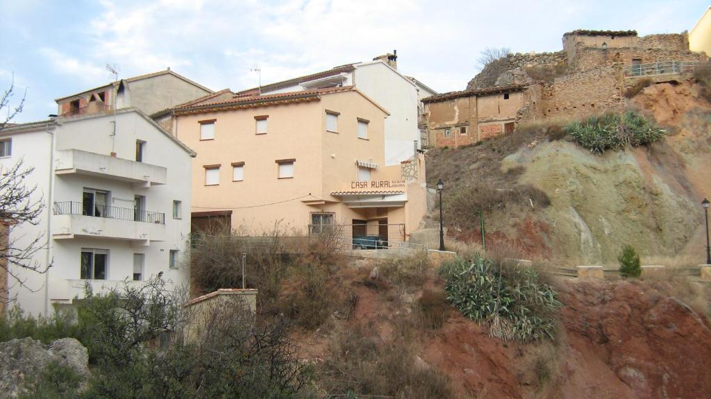 
a house with a stone wall and a building at Casa Serrana in Santa Cruz de Moya
