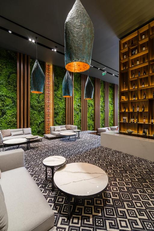 a lobby with couches and tables and plants at Unirea Hotel & Spa in Iaşi