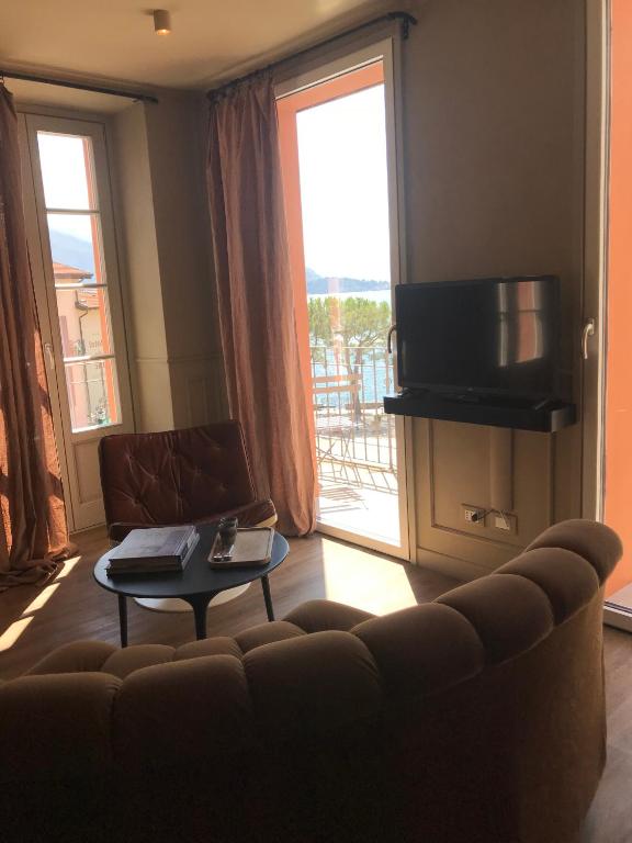 a living room with a couch and a table and a window at Suites Menaggio in Menaggio