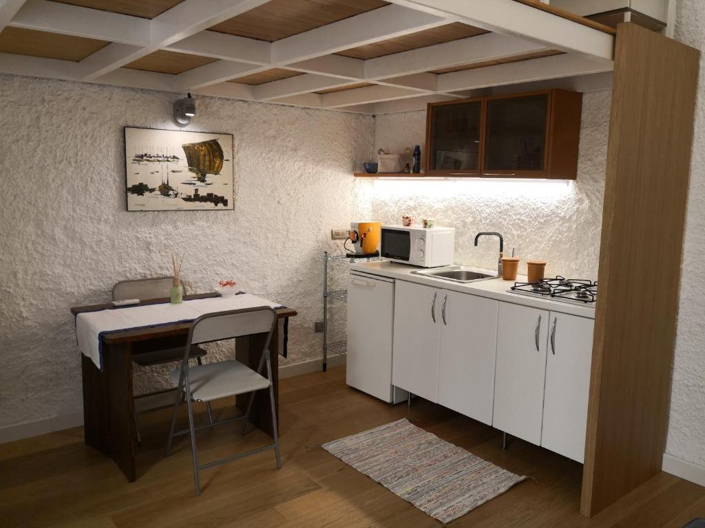 eine kleine Küche mit einem Tisch und einer Theke in der Unterkunft Dimora Vallisa in Bari