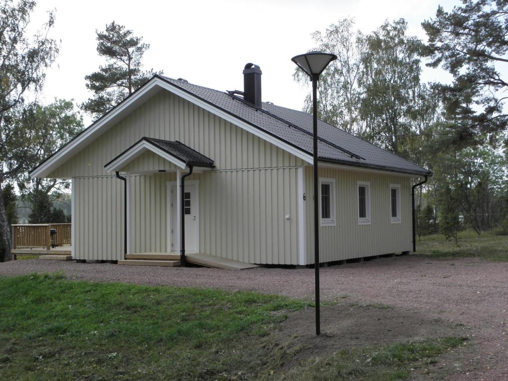 a large white building with a light pole in front of it at Söderö stugby in Finström