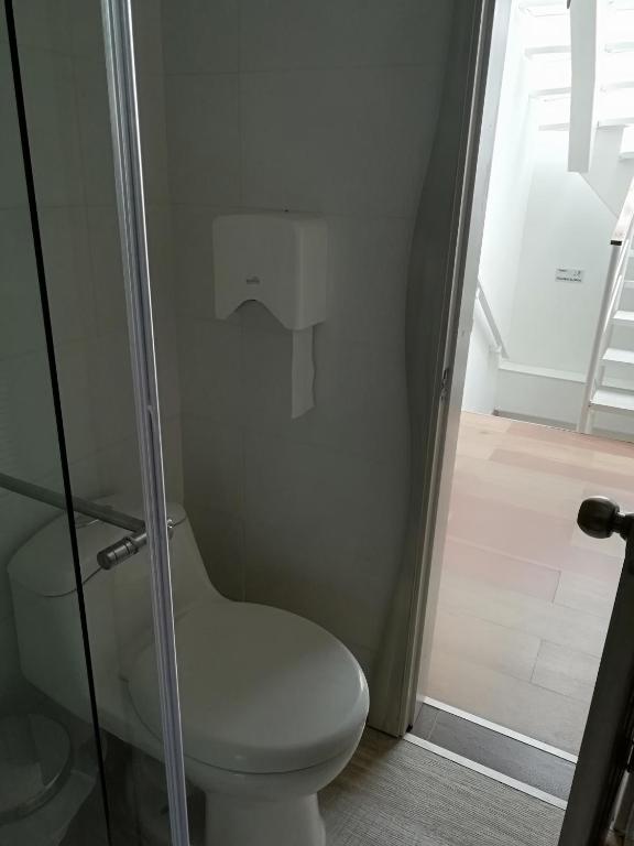 a bathroom with a toilet and a glass shower at Elizabetha Hostal in Salento