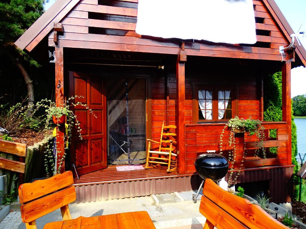 a small wooden cabin with a red door and two benches at Wysockie Zacisze in Osowa