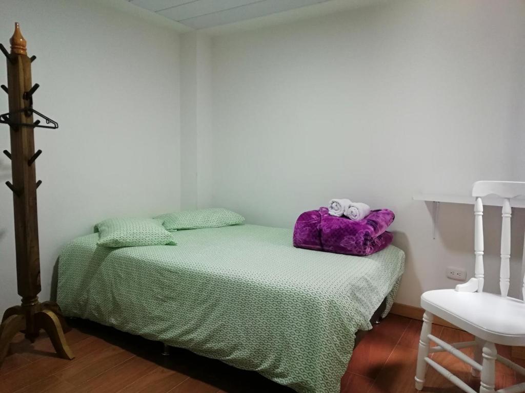 a bedroom with a bed with two stuffed animals on it at Elizabetha Hostal in Salento