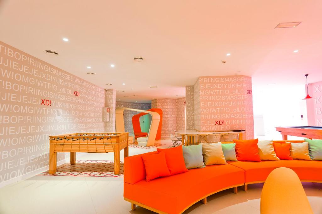 a living room with an orange couch and a table at Students XD in Granada