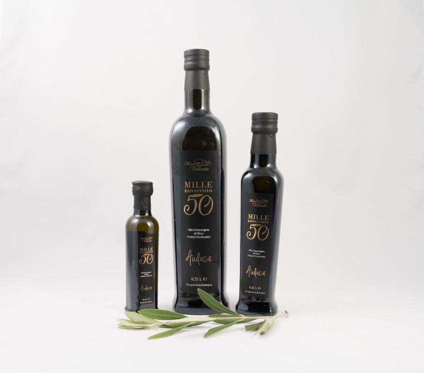 three bottles of wine with sage on a white background at Masseria Valente in Ostuni