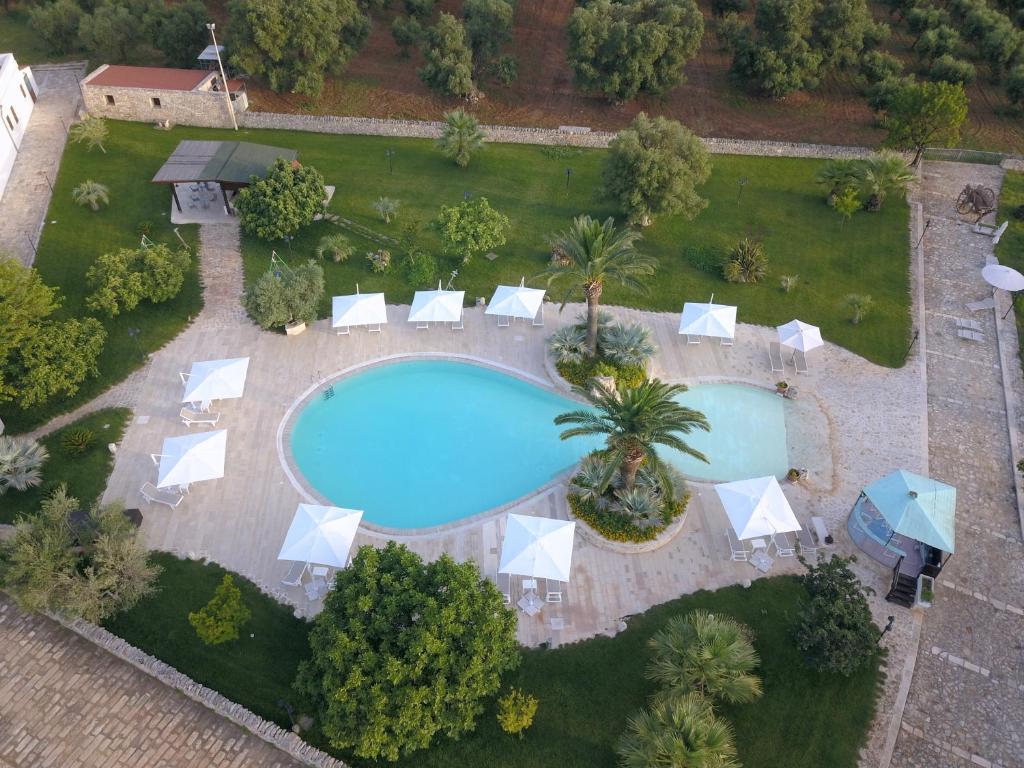an aerial view of a swimming pool with lounge chairs and a resort at Masseria Valente in Ostuni